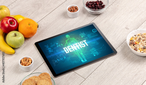 DENTIST concept in tablet with fruits, top view