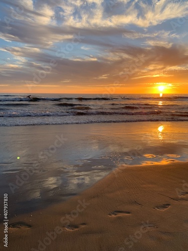 sunset on the beach with footsteps 