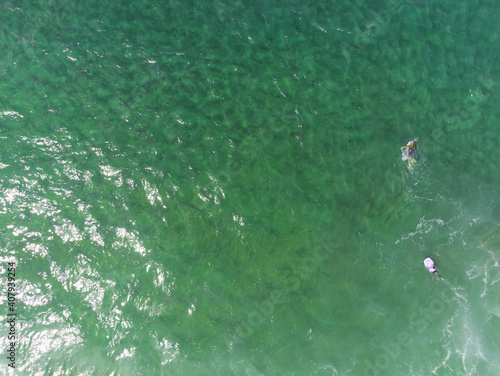 Aerial top down view on a surfers in the ocean. Sport and outdoor activity concept. Powerful waves