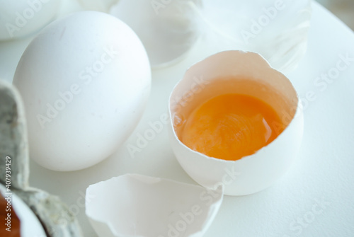 Chicken eggs in a tray on a white background, broken egg, white and yolk.