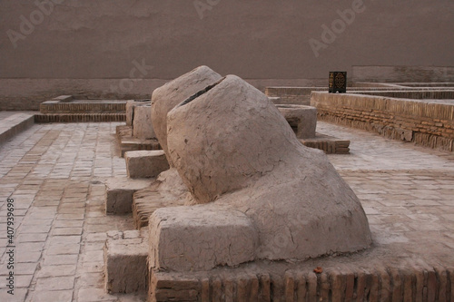 December 02 2019: old tandoor ovens for baking bread traditional tandoori bread on the background of Kunya Ark fortress and Kalta minor Minaret in Khiva photo