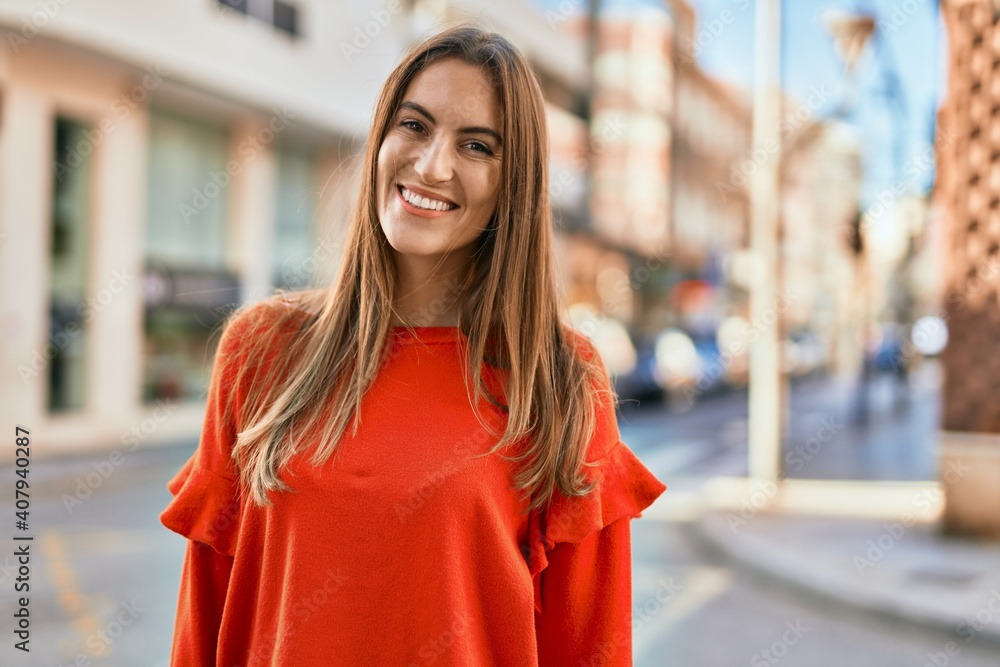 Young hispanic woman smiling happy standing at the city.