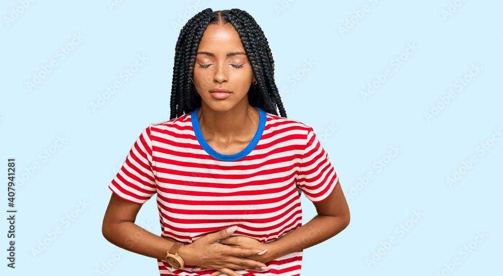 Beautiful hispanic woman wearing casual clothes with hand on stomach because indigestion, painful illness feeling unwell. ache concept.
