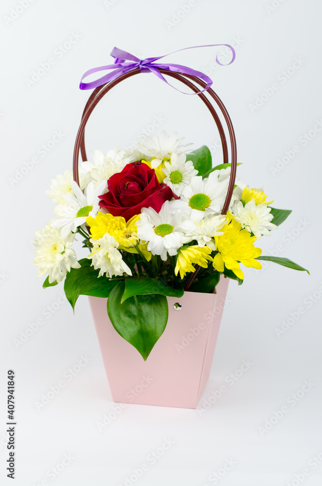 Bouquet of flowers in a paper basket on a white background