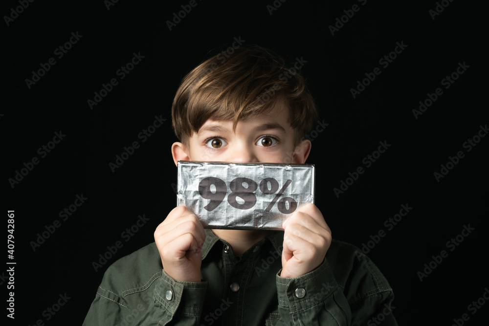 little boy holds a chocolate bar in foil little boy holds a chocolate bar in foil