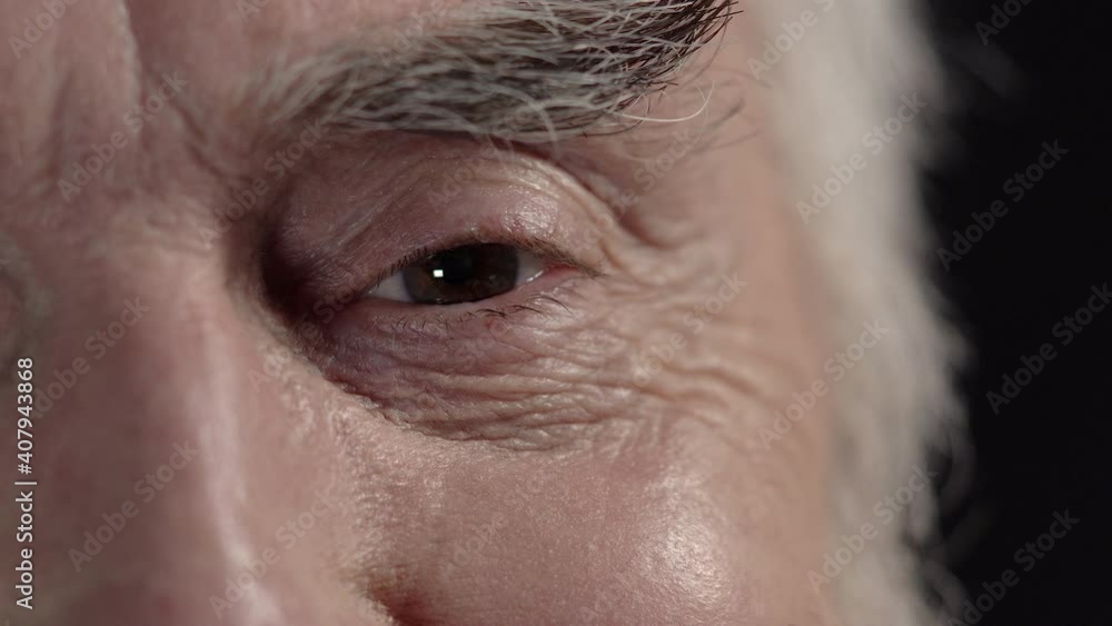 Gray haired mature man looking at camera and smiling, good mood, close up eye Gray haired mature man looking at camera and smiling, good mood, close up eye