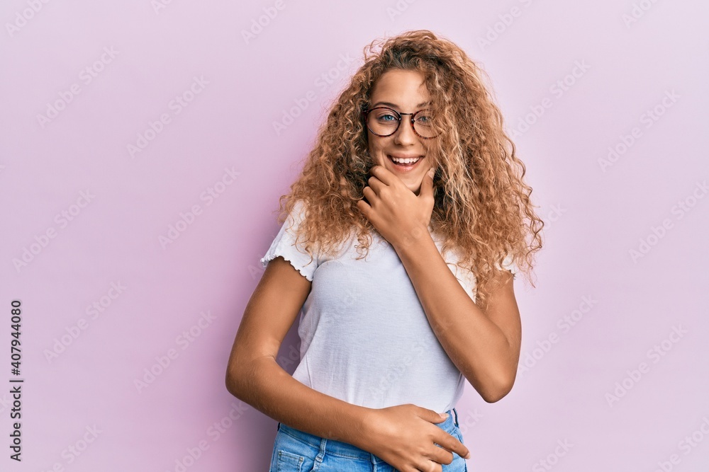 Beautiful caucasian teenager girl wearing white t-shirt over pink background looking confident at the camera smiling with crossed arms and hand raised on chin. thinking positive. Beautiful caucasian teenager girl wearing white t-shirt over pink background looking confident at the camera smiling with crossed arms and hand raised on chin. thinking positive.