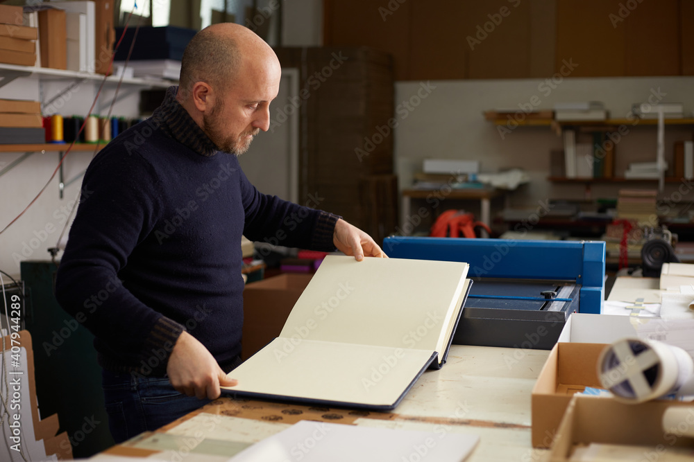 book binder working in a craft workshop book binder working in a craft workshop