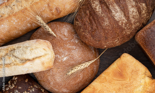 Different varieties of wheat and rye bread on a wooden table.