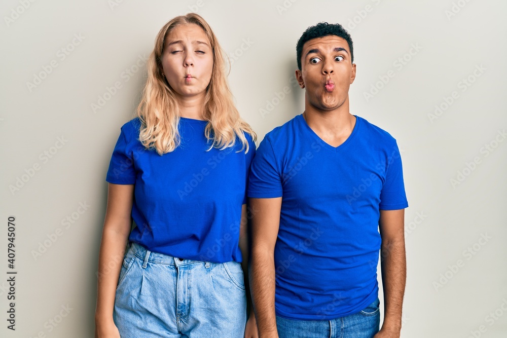 Young interracial couple wearing casual clothes making fish face with lips, crazy and comical gesture. funny expression. Young interracial couple wearing casual clothes making fish face with lips, crazy and comical gesture. funny expression.
