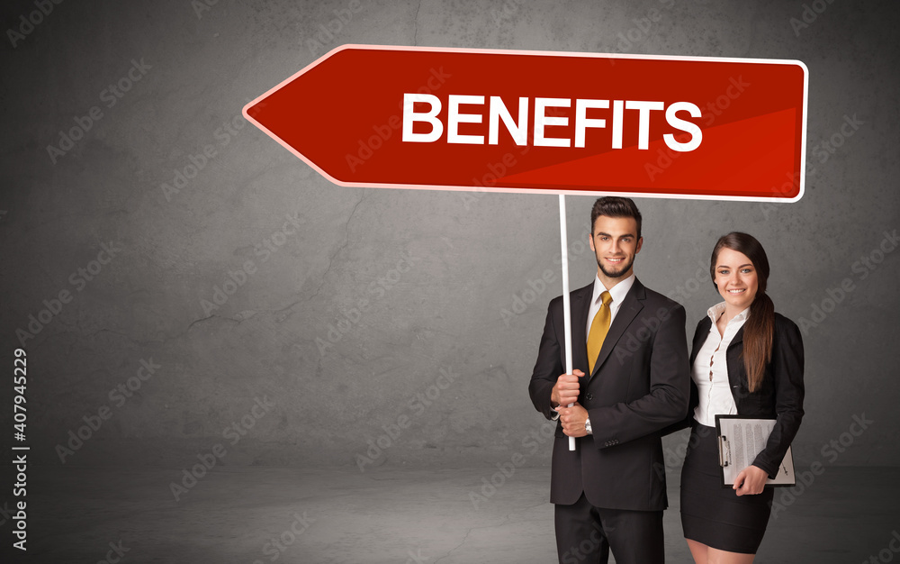 Young business person in casual holding road sign with BENEFITS inscription, new business direction concept Young business person in casual holding road sign with BENEFITS inscription, new business direction concept