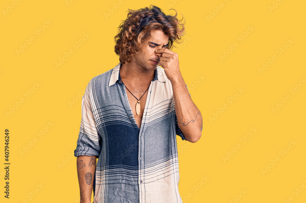 Young hispanic man wearing summer style tired rubbing nose and eyes feeling fatigue and headache. stress and frustration concept. Young hispanic man wearing summer style tired rubbing nose and eyes feeling fatigue and headache. stress and frustration concept.