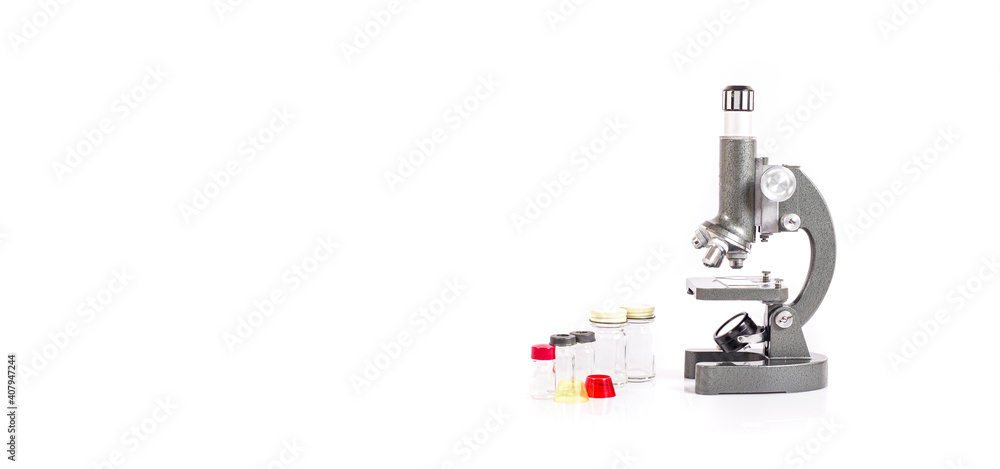 old microscope and glass vials on white table