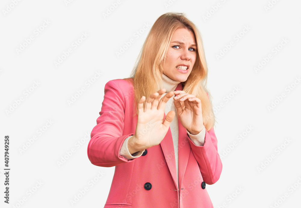 Young beautiful blonde woman wearing elegant clothes disgusted expression, displeased and fearful doing disgust face because aversion reaction. with hands raised Young beautiful blonde woman wearing elegant clothes disgusted expression, displeased and fearful doing disgust face because aversion reaction. with hands raised