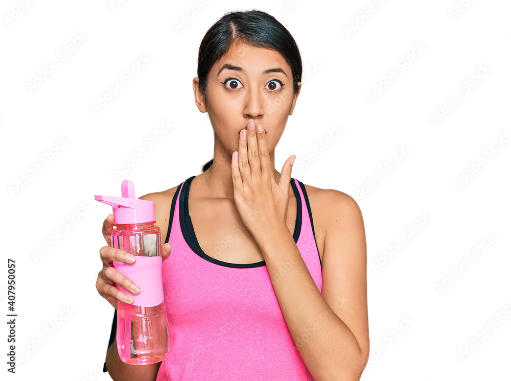 Beautiful asian young sport woman wearing sportswear drinking bottle of water covering mouth with hand, shocked and afraid for mistake. surprised expression Beautiful asian young sport woman wearing sportswear drinking bottle of water covering mouth with hand, shocked and afraid for mistake. surprised expression