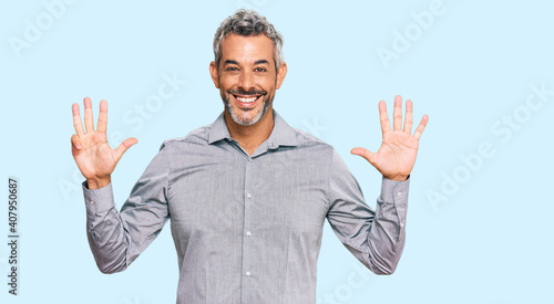 Middle age grey-haired man wearing casual clothes showing and pointing up with fingers number nine while smiling confident and happy. © Krakenimages.com