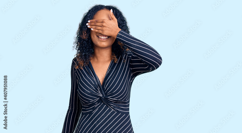 Young african american woman wearing casual clothes and glasses smiling and laughing with hand on face covering eyes for surprise. blind concept. Young african american woman wearing casual clothes and glasses smiling and laughing with hand on face covering eyes for surprise. blind concept.