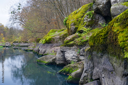 Large stones overgrown with moss lie near the water.
