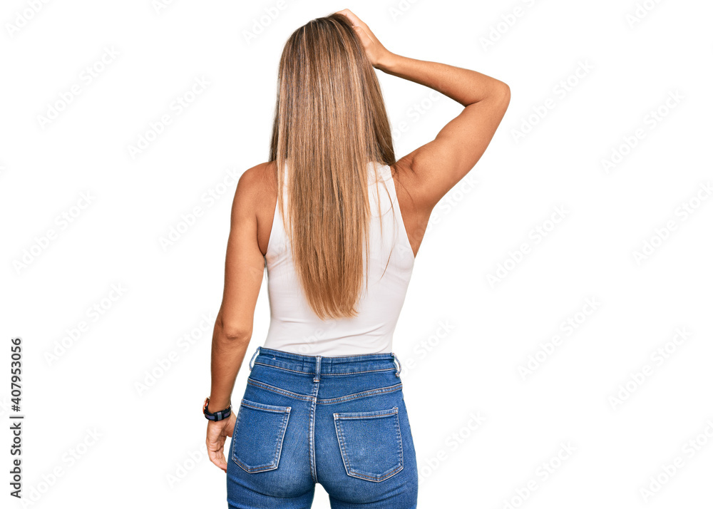 Young blonde woman wearing casual style with sleeveless shirt backwards thinking about doubt with hand on head Young blonde woman wearing casual style with sleeveless shirt backwards thinking about doubt with hand on head