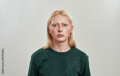 Portrait of young caucasian man with long blond hair