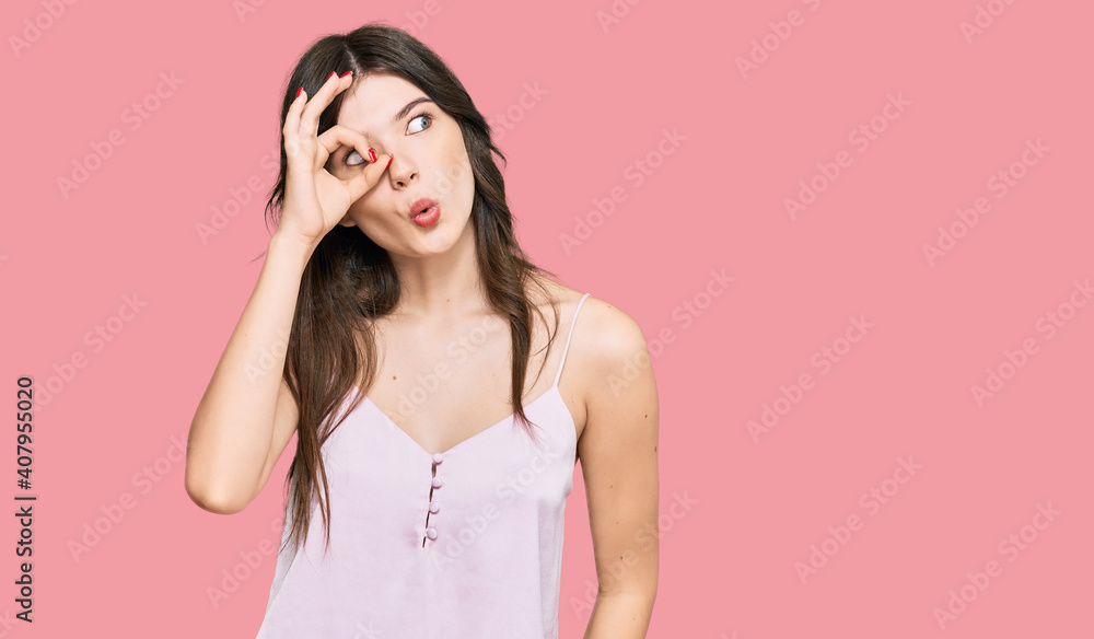 Young beautiful caucasian girl wearing casual clothes doing ok gesture shocked with surprised face, eye looking through fingers. unbelieving expression. Young beautiful caucasian girl wearing casual clothes doing ok gesture shocked with surprised face, eye looking through fingers. unbelieving expression.