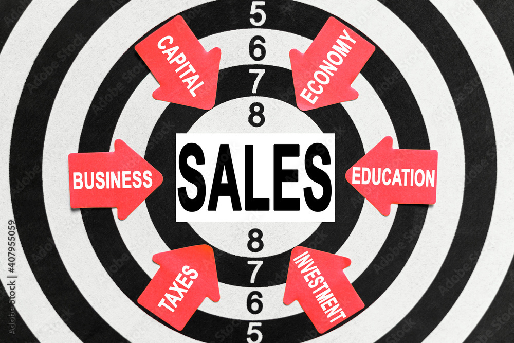 On the target, arrows with business lettering point to the center on a business card with the inscription - SALES On the target, arrows with business lettering point to the center on a business card with the inscription - SALES