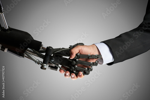 cooperation of people and machines . The robot shakes the man's hand
