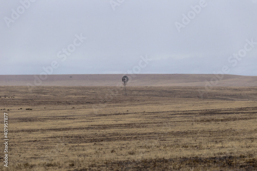 Wallpaper Mural Lonely windmill in middle of giant open yellow field in rural New Mexico on cloudy day Torontodigital.ca