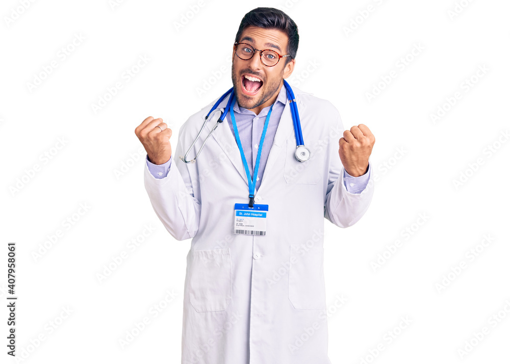 Young hispanic man wearing doctor uniform and stethoscope very happy and excited doing winner gesture with arms raised, smiling and screaming for success. celebration concept. Young hispanic man wearing doctor uniform and stethoscope very happy and excited doing winner gesture with arms raised, smiling and screaming for success. celebration concept.