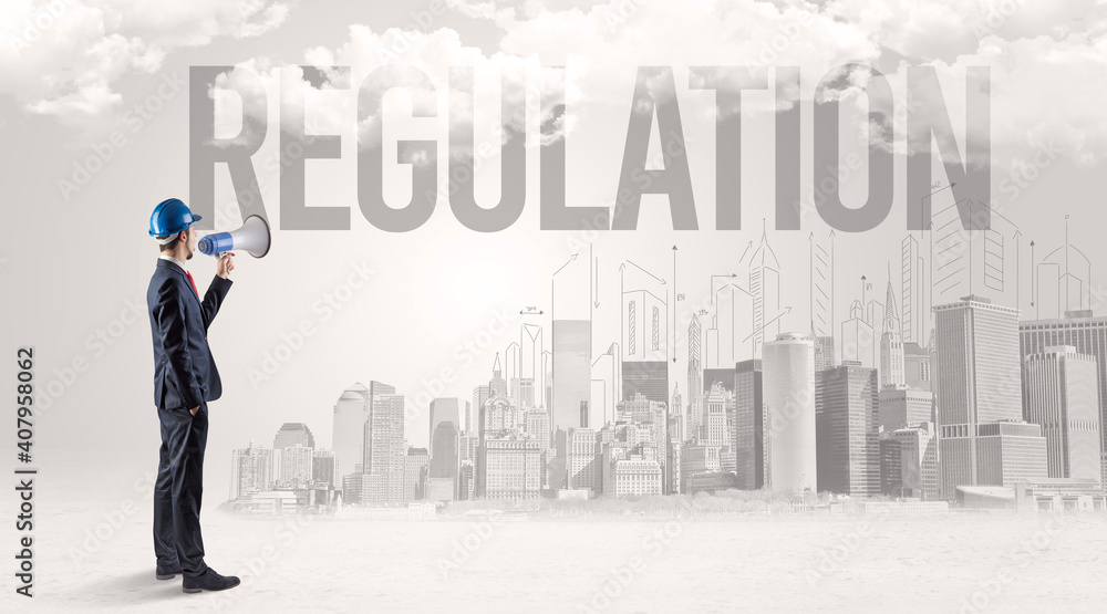 Young businessman with hard hat and REGULATION inscription, new business opportunity concept Young businessman with hard hat and REGULATION inscription, new business opportunity concept