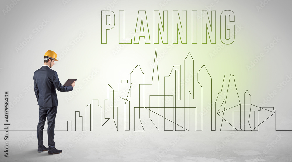 Businessman in hard hat holding blueprint with PLANNING inscription, engineering and architecture concept