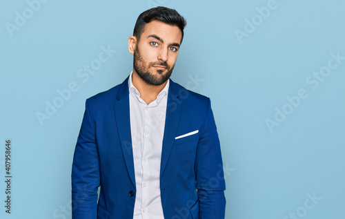 Young hispanic man wearing business jacket looking sleepy and tired, exhausted for fatigue and hangover, lazy eyes in the morning.