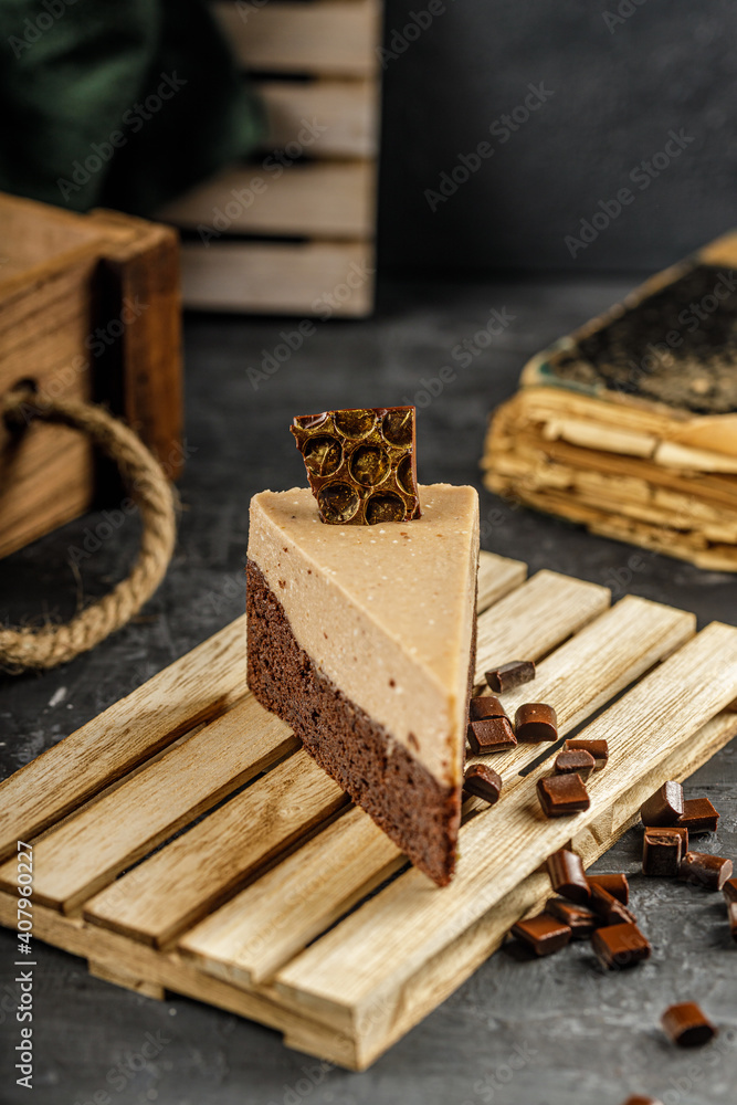 Still life of chestnut cake with chocolate mousse on a dark gray table with chocolate pieces. Still life of chestnut cake with chocolate mousse on a dark gray table with chocolate pieces.