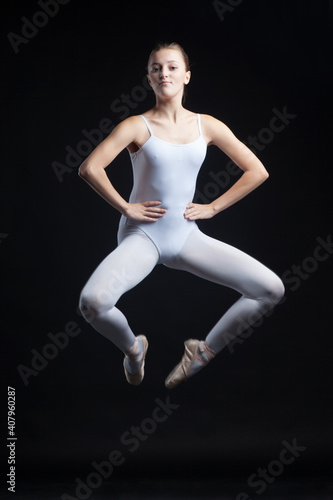 young gymnastic ballet dancer dancing in white body isolated on black background