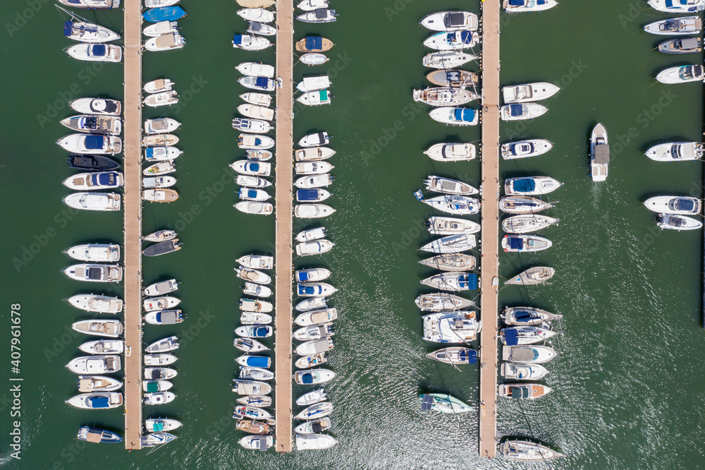 Top straight down aerial drone photo of the beautiful island of Ibiza in Spain showing the boating harbour with rows of speed and sail boats in the harbour on a bright sunny summers day