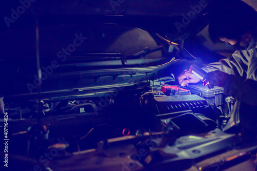 Selec tive focus to the mechanic's hand is unscrewing a nut to replace the car battery. Delivery car maintenance on road or home. The concepts of car maintenance services in every location.