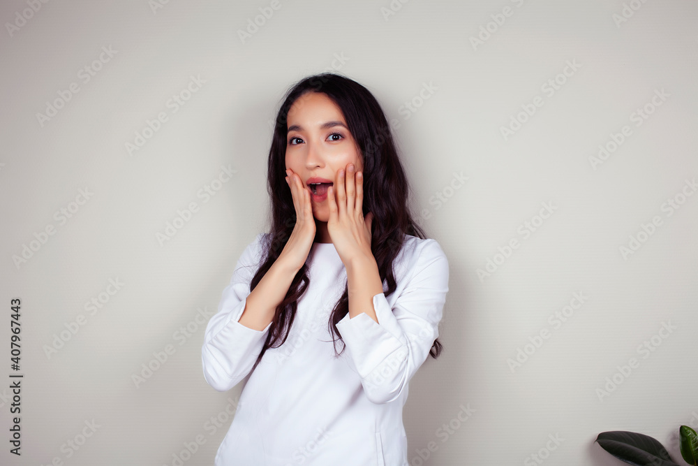 young asian woman doctor in white uniform gesturing positive on gray background, lifestyle healthcare people concept young asian woman doctor in white uniform gesturing positive on gray background, lifestyle healthcare people concept
