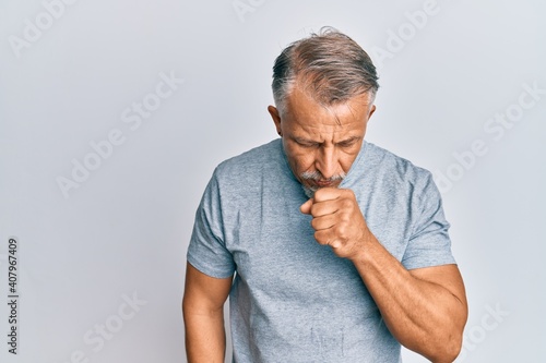 Middle age grey-haired man wearing casual clothes feeling unwell and coughing as symptom for cold or bronchitis. health care concept.