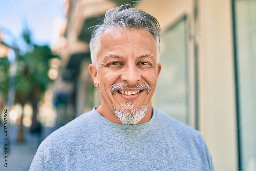 Middle age hispanic grey-haired man smiling happy standing at the city. Middle age hispanic grey-haired man smiling happy standing at the city.