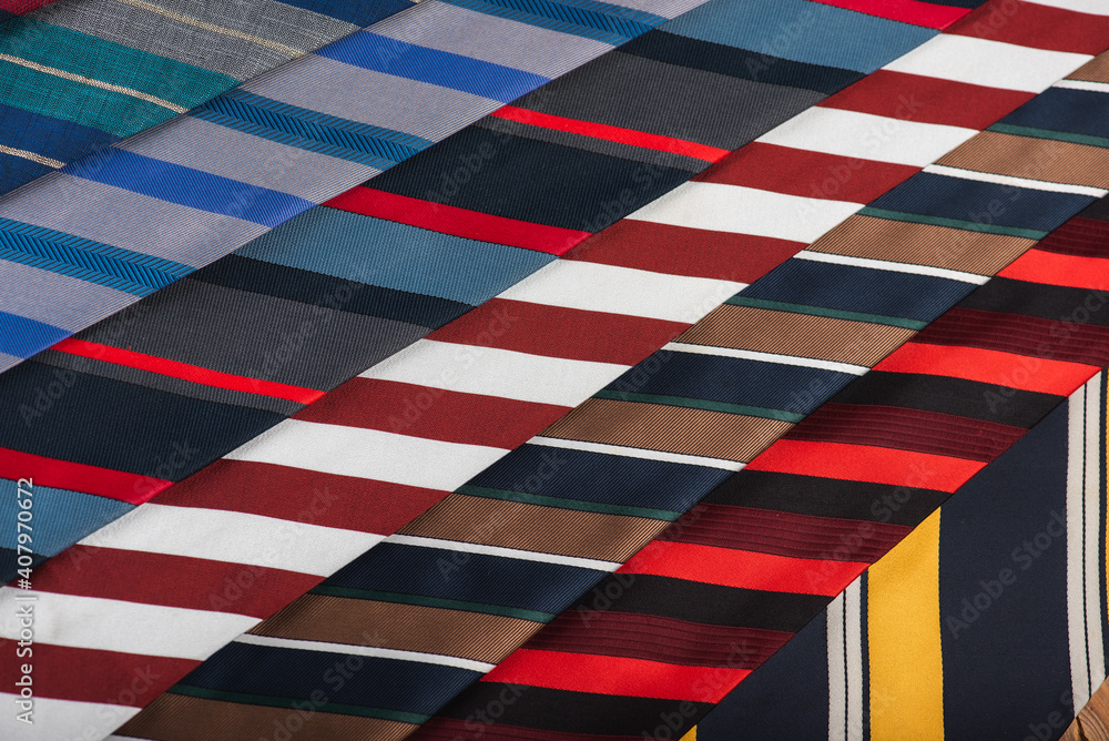 close-up view, many colorful folded ties, sloping horizon. Textured background of classic fabrics close-up view, many colorful folded ties, sloping horizon. Textured background of classic fabrics