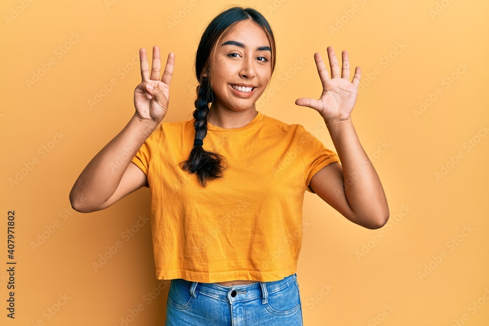 Young latin woman wearing casual clothes showing and pointing up with fingers number eight while smiling confident and happy. Young latin woman wearing casual clothes showing and pointing up with fingers number eight while smiling confident and happy.