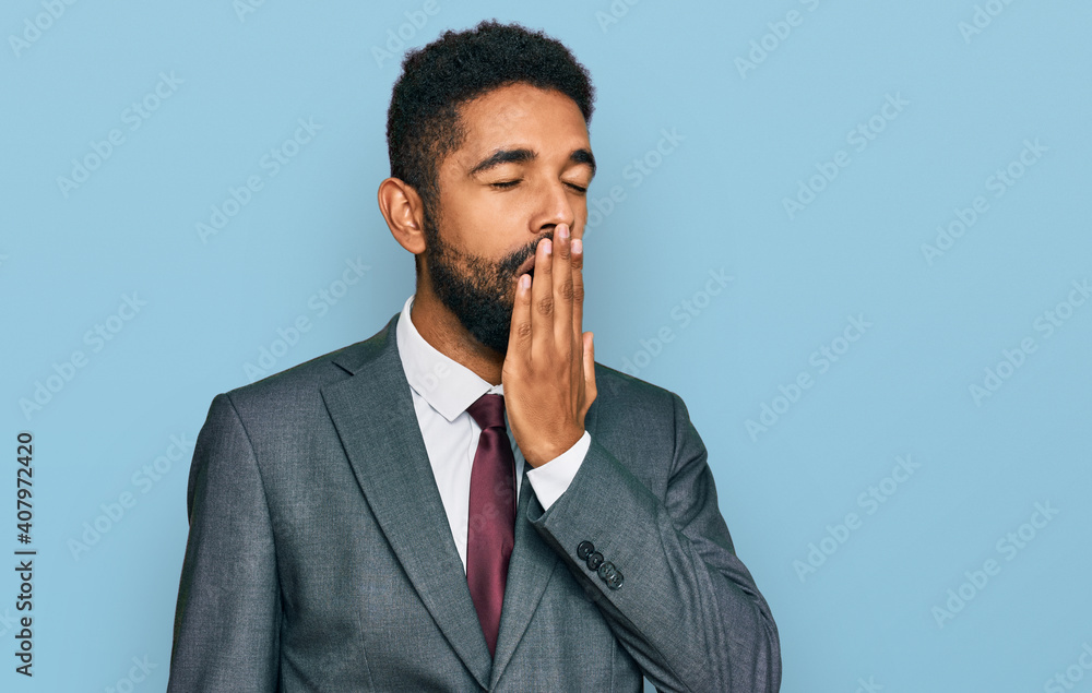 Young african american man wearing business clothes bored yawning tired covering mouth with hand. restless and sleepiness. Young african american man wearing business clothes bored yawning tired covering mouth with hand. restless and sleepiness.