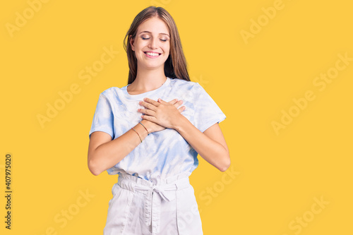 Photography Young beautiful blonde woman wearing tye die tshirt smiling with hands on chest with closed eyes and grateful gesture on face