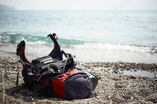 Close-up of a hiking backpack on the seashore on a sunny summer day.