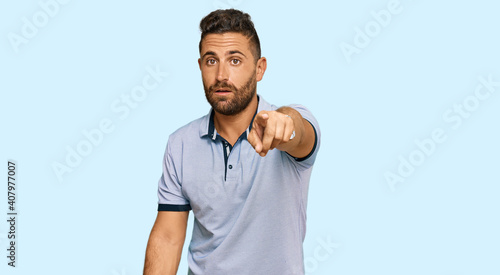 Handsome man with beard wearing casual clothes pointing displeased and frustrated to the camera, angry and furious with you