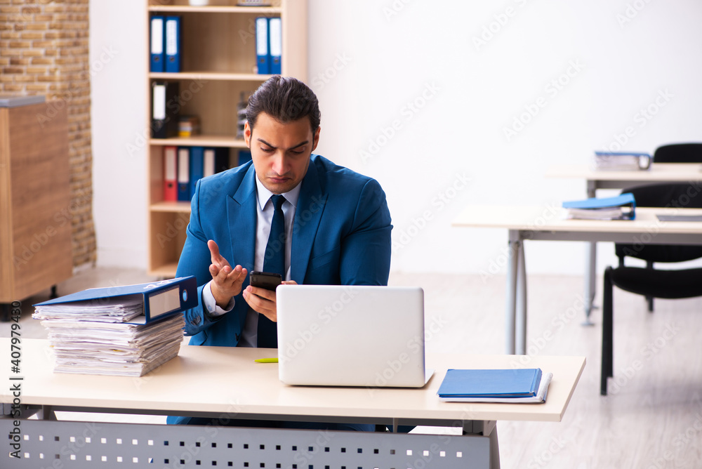 Young male employee sitting in the office Young male employee sitting in the office