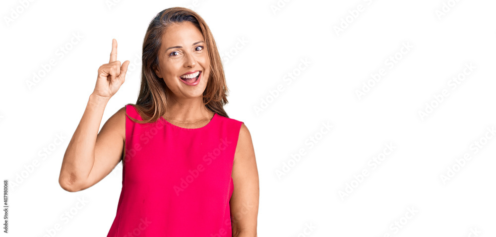Middle age hispanic woman wearing casual clothes pointing finger up with successful idea. exited and happy. number one. Middle age hispanic woman wearing casual clothes pointing finger up with successful idea. exited and happy. number one.