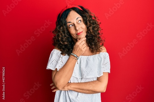 Obraz na plátně Middle age hispanic woman wearing casual clothes with hand on chin thinking about question, pensive expression