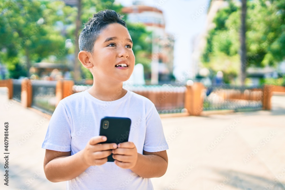 Adorable boy smiling happy using smartphone at street of city. Adorable boy smiling happy using smartphone at street of city.