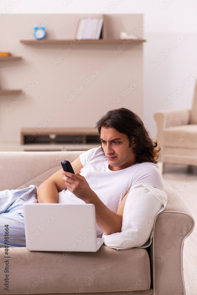 Young lazy man in oversleeping concept at home Young lazy man in oversleeping concept at home